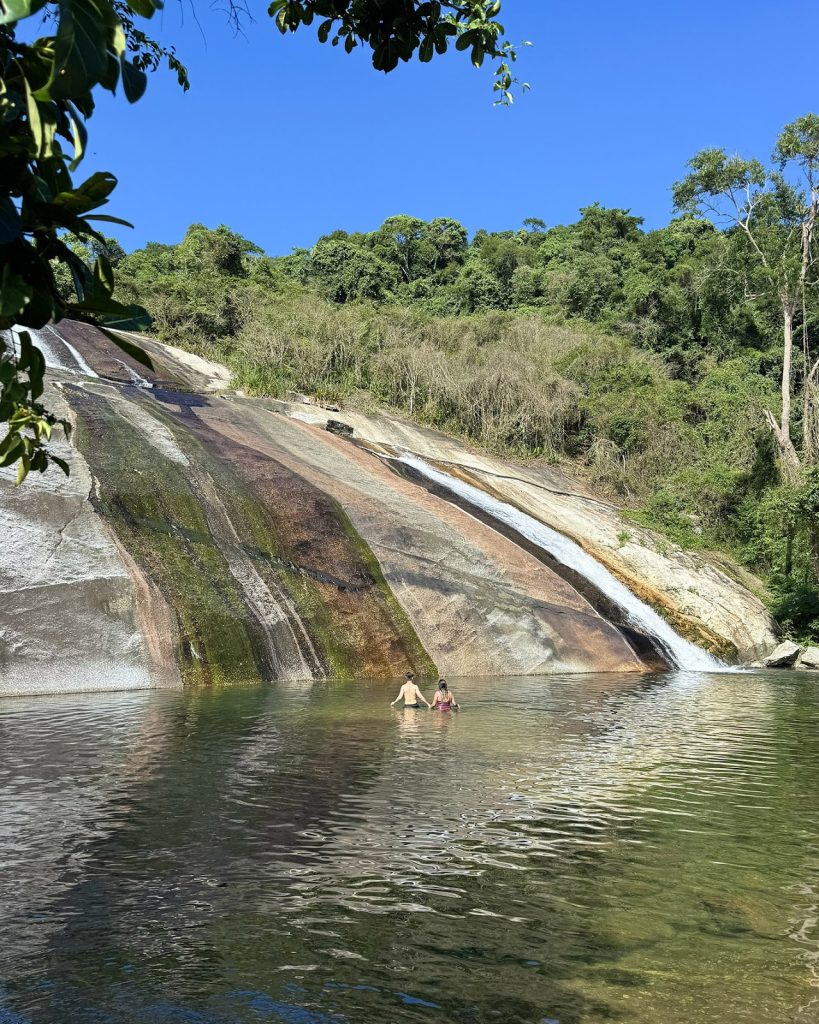 poço grande da cachoeira do Paquetá com casal e cascata ao fundo