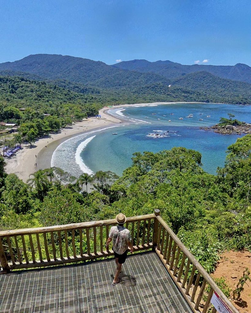 vista aérea do Mirante do coação com homem olhando para o mar que aparece no formato de coração ao fundo
