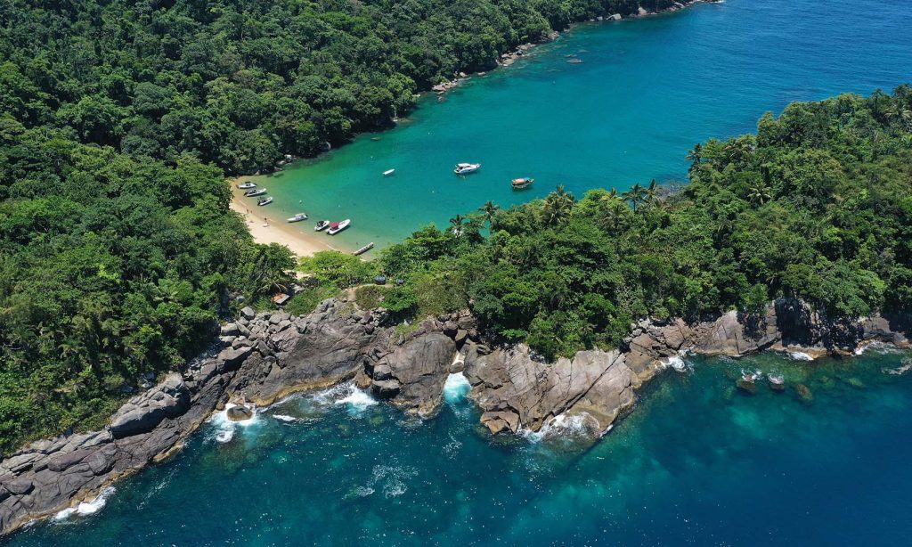 Vista aérea da Praia do Eustáquio em Ilhabela com aguas transparentes e azuis