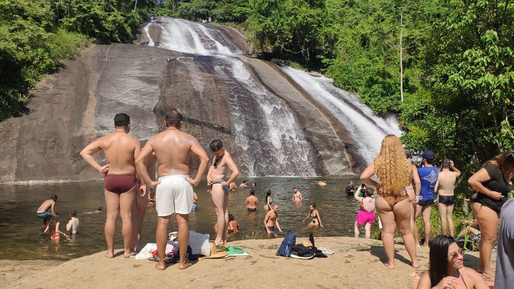Poço da Cachoeira do Paquetá com muitas pessoas que frequentam em horário de pico, cachoeira lotada em finais de semana e feriados prolongados em Ilhabela.
