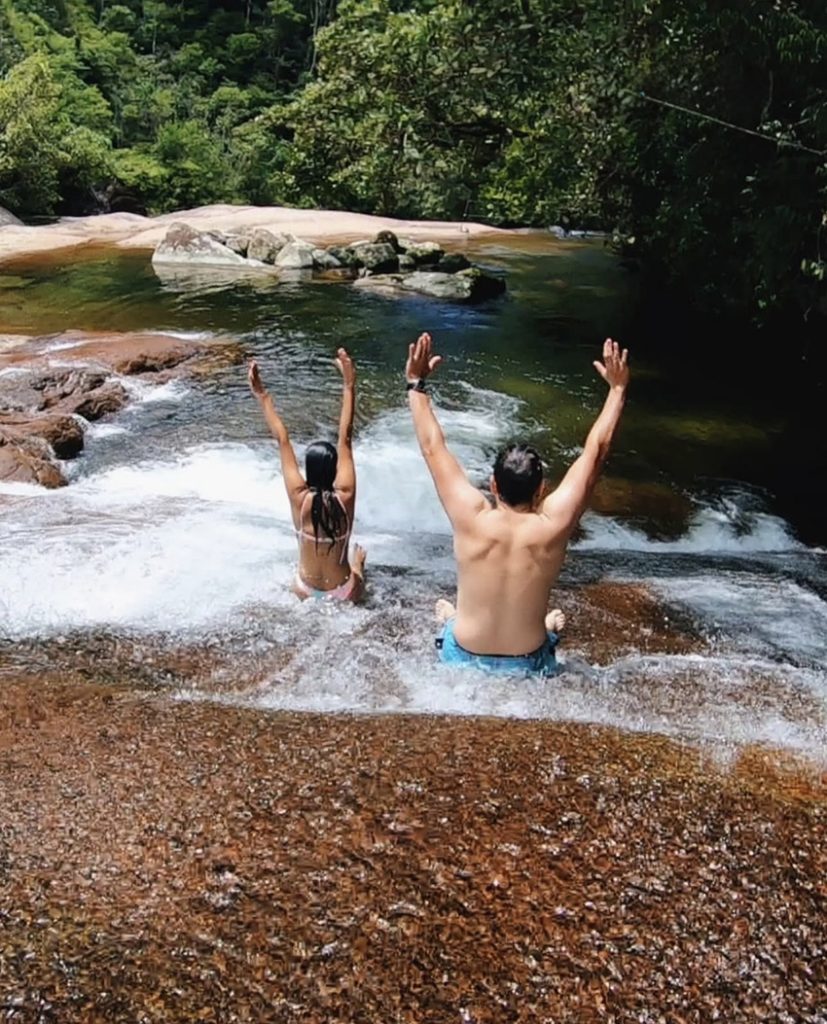 Casal escorregando tobogã cachoeira lage Ilhabela
